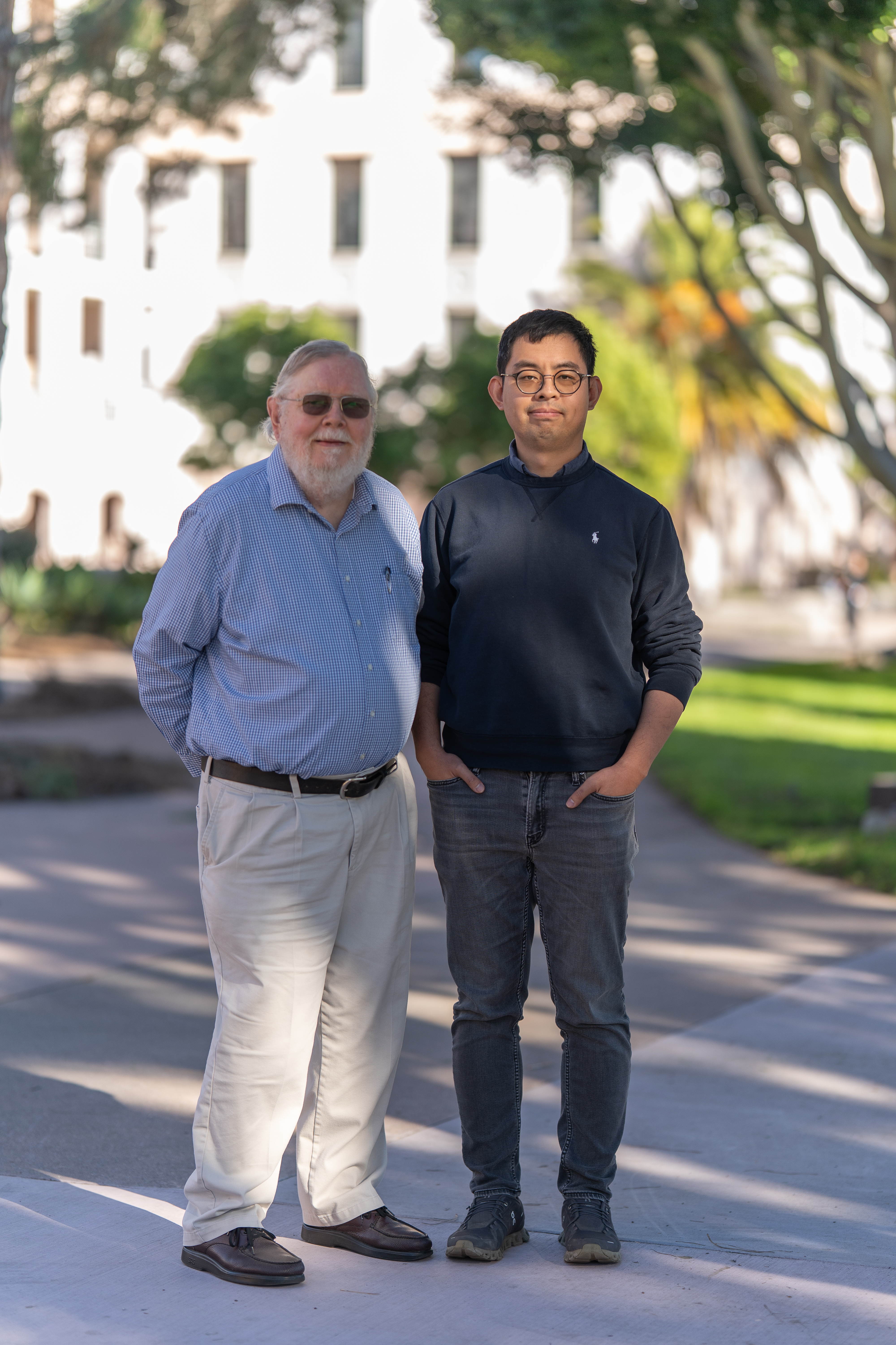 Emeritus Professor Stanley Parsons standing side-by-side with Assistant Professor Yang Hai outdoors.