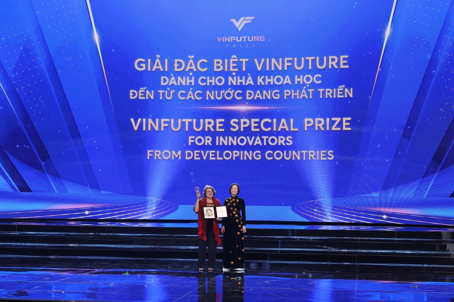 Thuc-Quyen Nguyen stands onstage beside an award recipient beneath a screen announcing the VinFuture Special Prize for Innovators from Developing Countries.