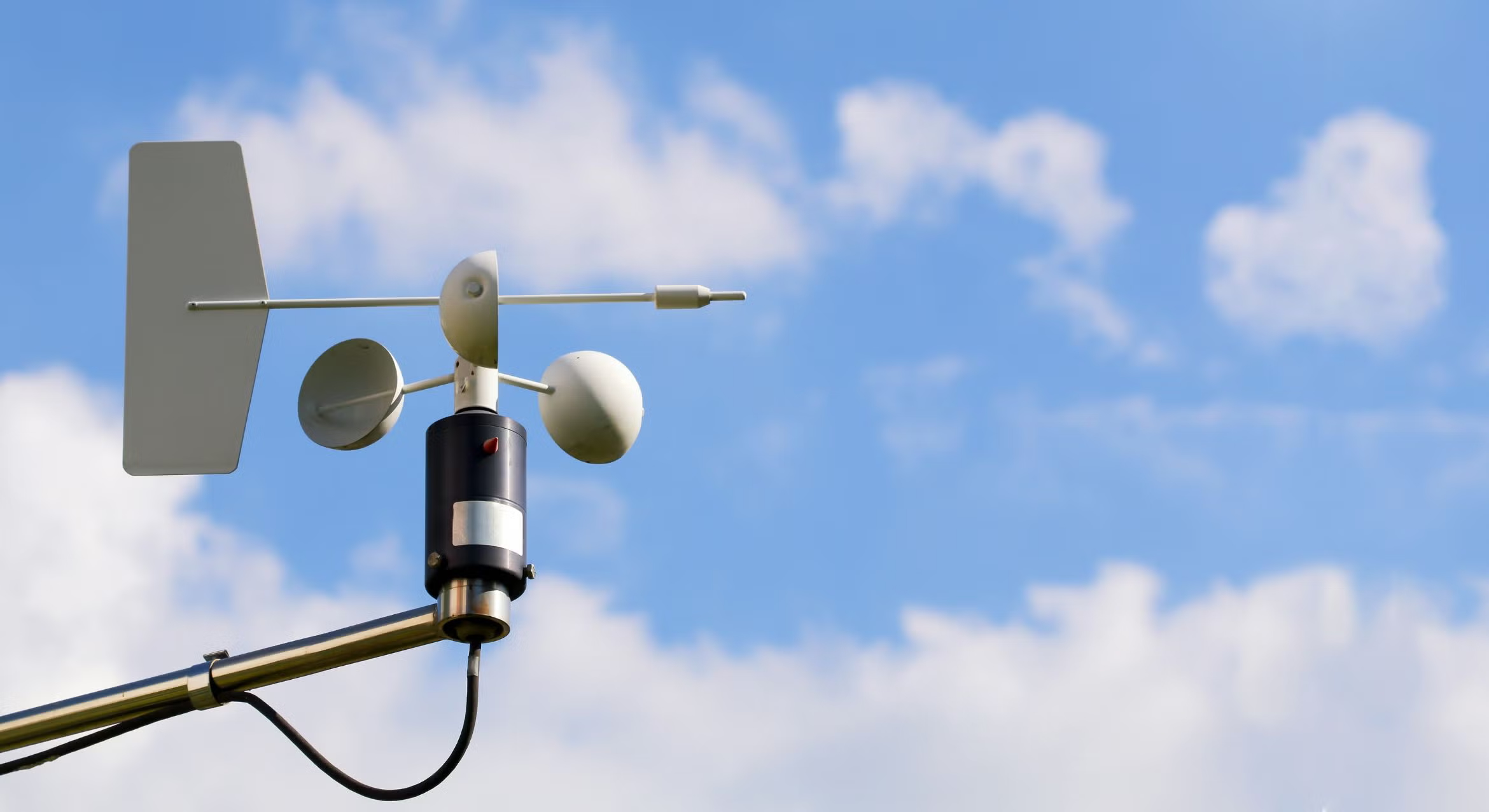 Weather station instrumentation against a blue, cloudy sky.