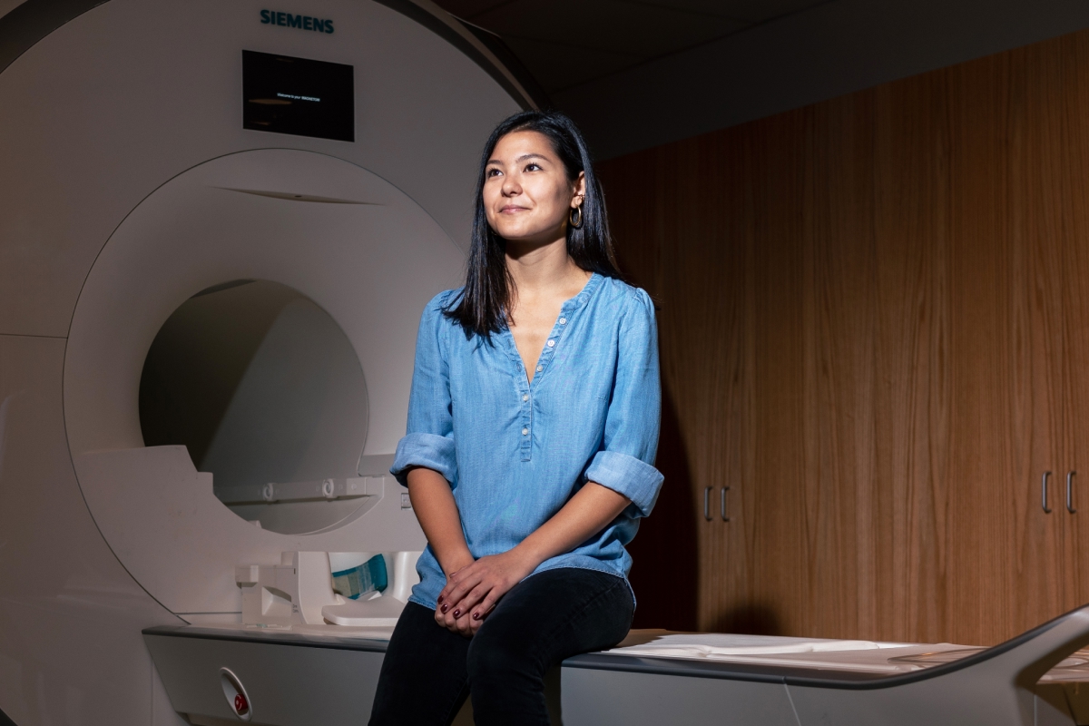 Woman sitting on MRI machine