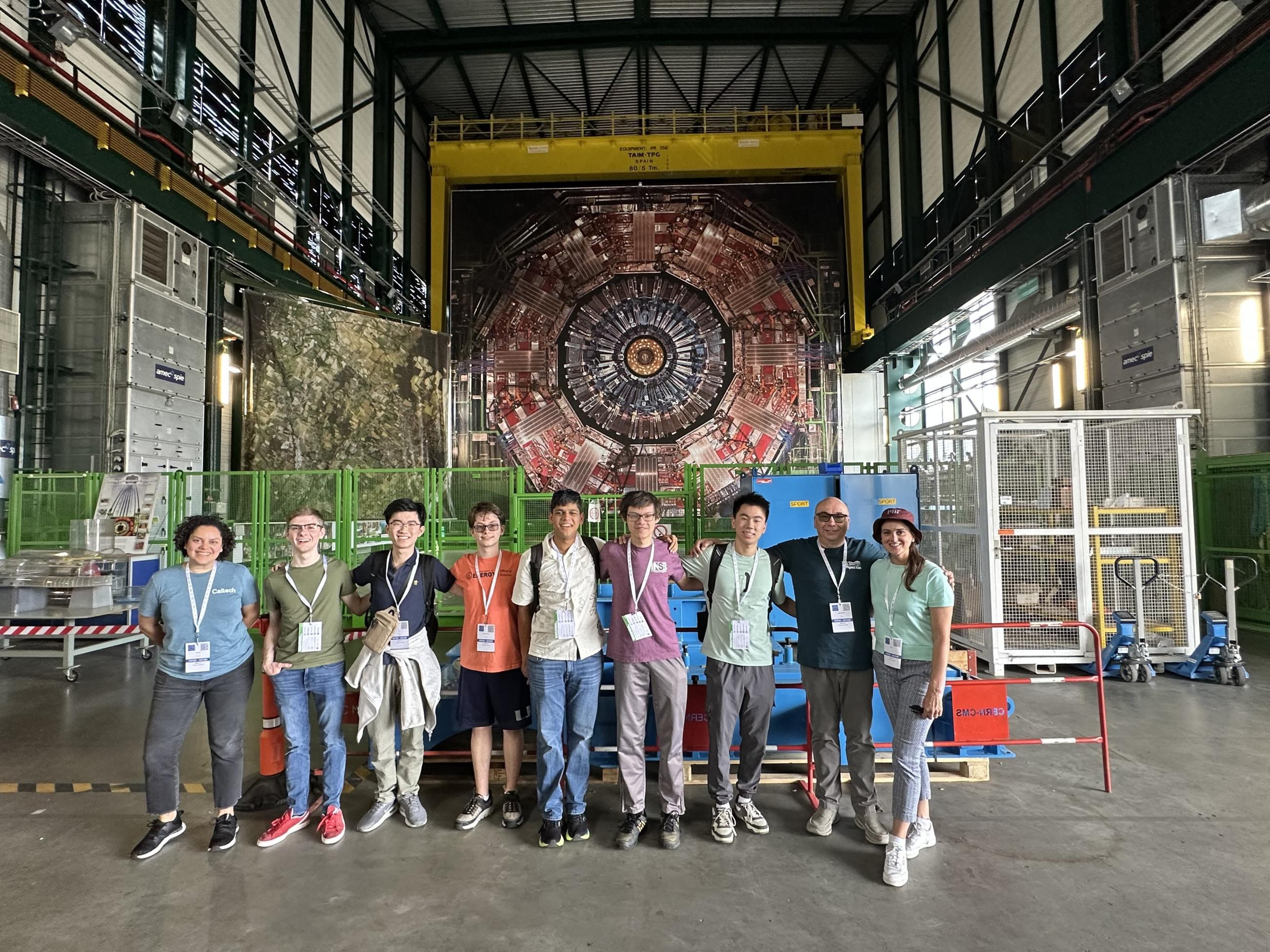 The U.S. Physics Team and their guides stand in front of the massive CMS particle detector at CERN.